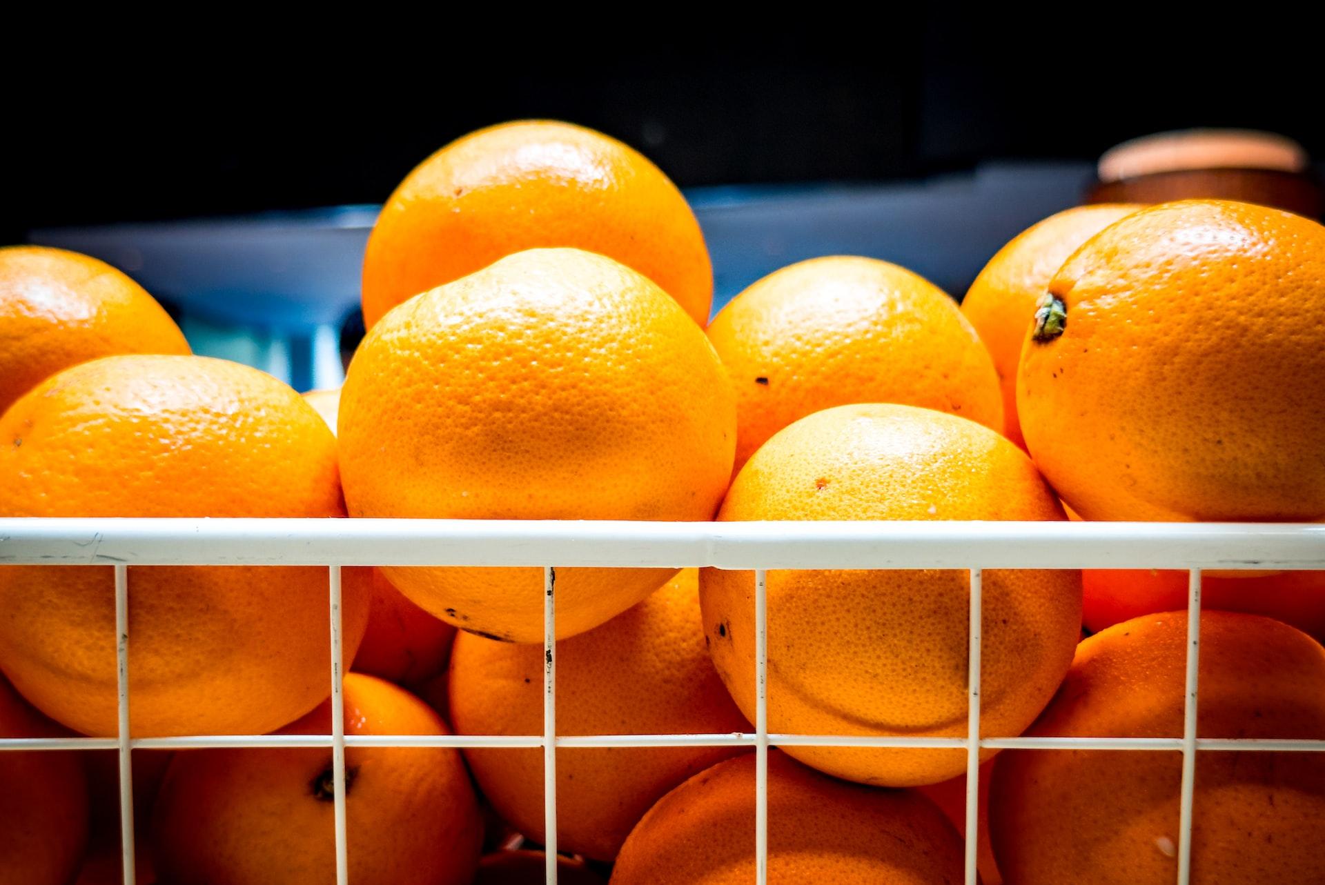 a bunch of oranges are stacked in a basket